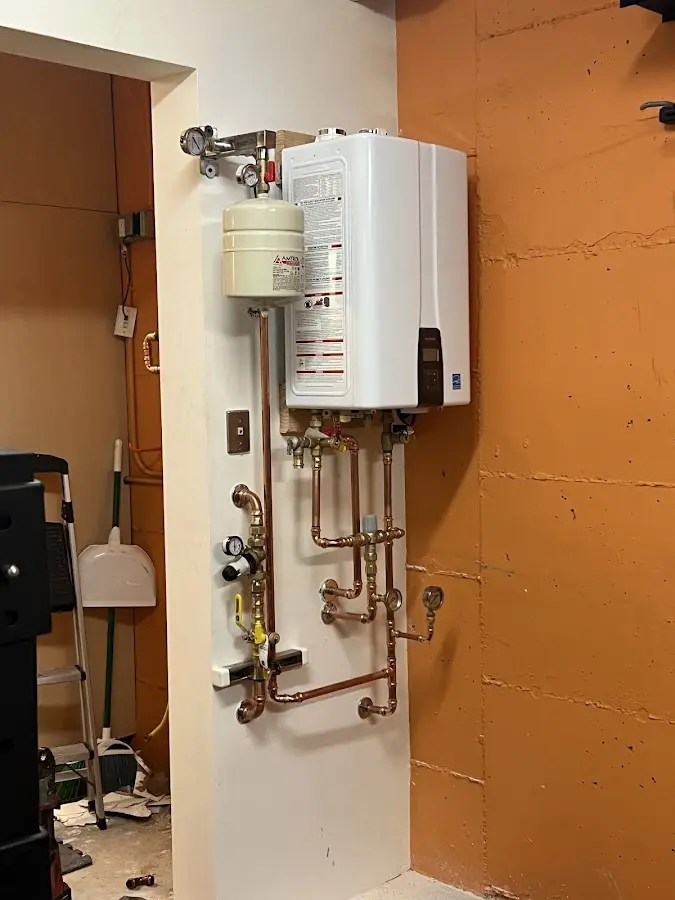 Plumbing technician inspecting water heater connections in Oroville